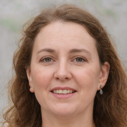 Joyful white adult female with long  brown hair and grey eyes