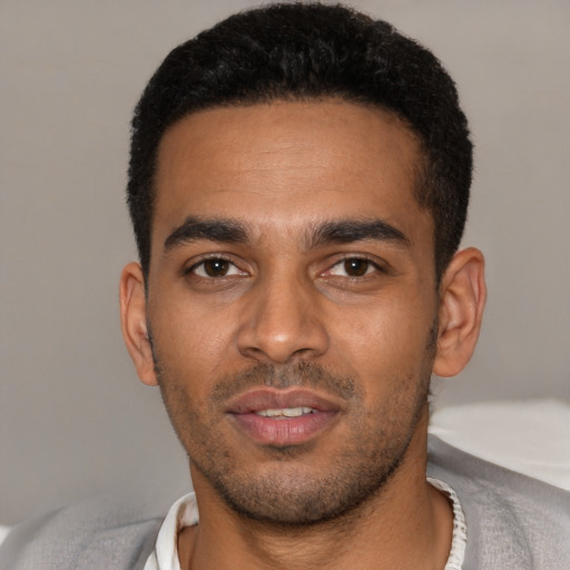 Joyful latino young-adult male with short  black hair and brown eyes