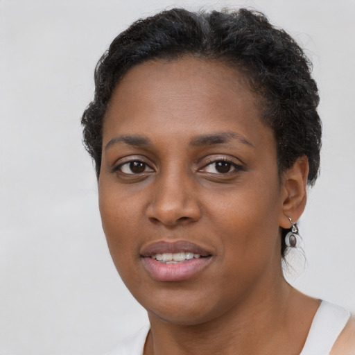 Joyful black young-adult female with short  brown hair and brown eyes