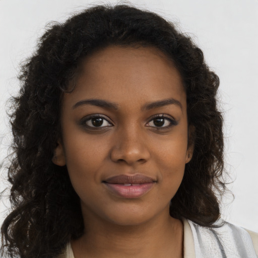 Joyful black young-adult female with long  brown hair and brown eyes