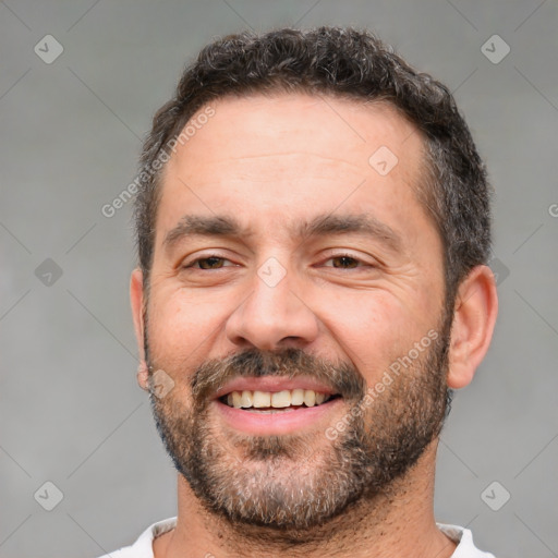 Joyful white adult male with short  brown hair and brown eyes