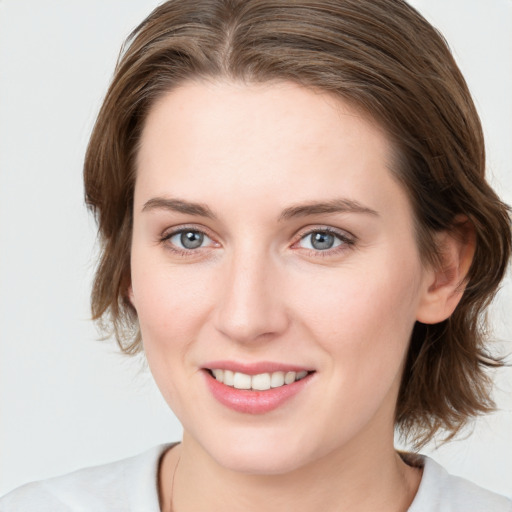 Joyful white young-adult female with medium  brown hair and blue eyes