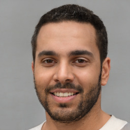 Joyful white young-adult male with short  black hair and brown eyes