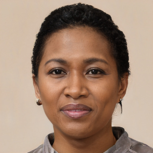 Joyful black adult female with short  black hair and brown eyes
