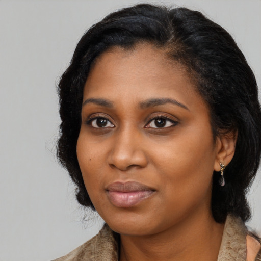 Joyful black young-adult female with long  black hair and brown eyes