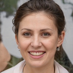 Joyful white adult female with medium  brown hair and brown eyes