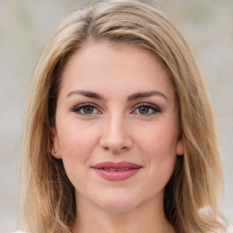 Joyful white young-adult female with medium  brown hair and green eyes