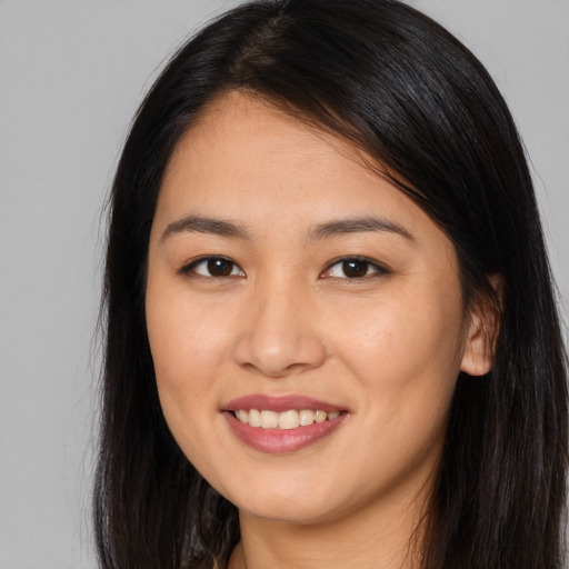 Joyful asian young-adult female with long  brown hair and brown eyes