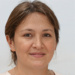 Joyful white adult female with medium  brown hair and brown eyes