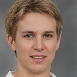 Joyful white young-adult male with short  brown hair and grey eyes