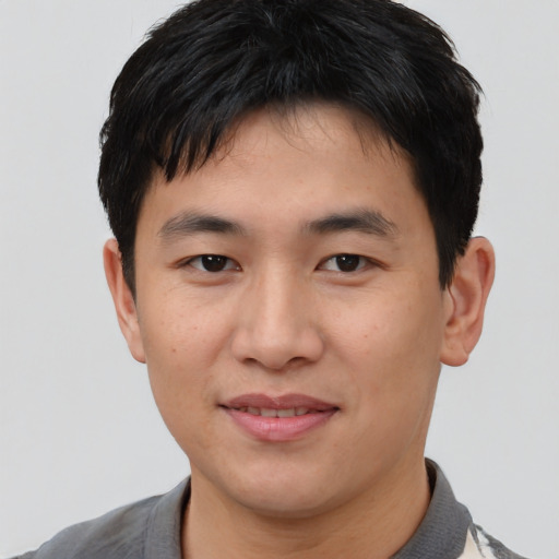 Joyful asian young-adult male with short  black hair and brown eyes