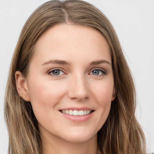 Joyful white young-adult female with long  brown hair and grey eyes