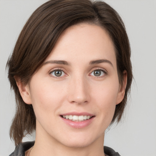 Joyful white young-adult female with medium  brown hair and grey eyes