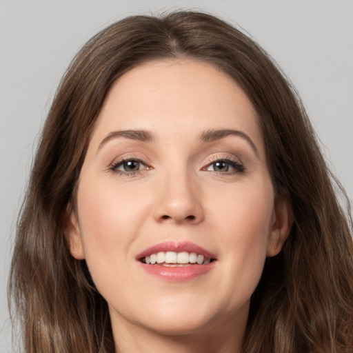 Joyful white young-adult female with long  brown hair and brown eyes