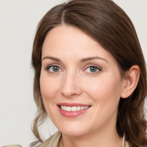 Joyful white young-adult female with medium  brown hair and grey eyes