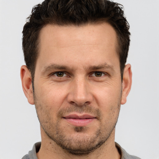 Joyful white adult male with short  brown hair and brown eyes