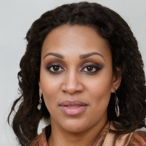 Joyful black young-adult female with long  brown hair and brown eyes
