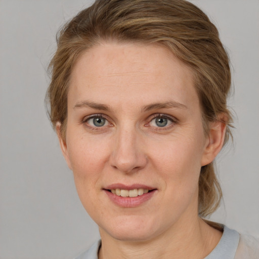 Joyful white adult female with medium  brown hair and blue eyes