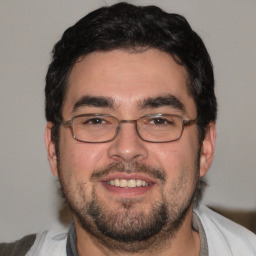 Joyful white young-adult male with short  black hair and brown eyes