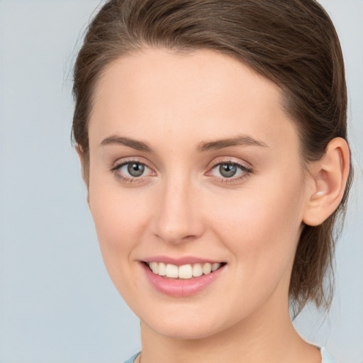 Joyful white young-adult female with medium  brown hair and green eyes