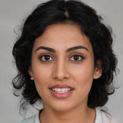 Joyful latino young-adult female with medium  brown hair and brown eyes