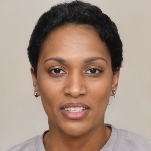 Joyful black young-adult female with short  black hair and brown eyes