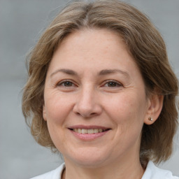 Joyful white adult female with medium  brown hair and brown eyes