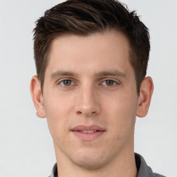 Joyful white young-adult male with short  brown hair and grey eyes