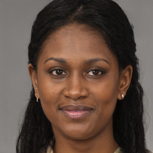 Joyful black young-adult female with long  brown hair and brown eyes