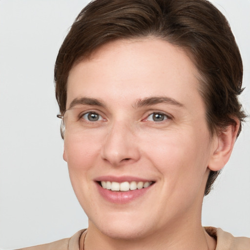 Joyful white young-adult female with short  brown hair and grey eyes