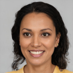 Joyful latino young-adult female with long  brown hair and brown eyes