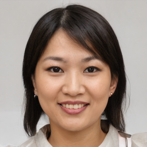 Joyful asian young-adult female with medium  brown hair and brown eyes