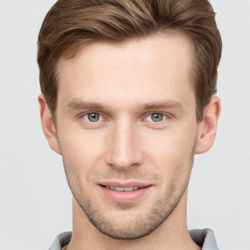 Joyful white young-adult male with short  brown hair and grey eyes