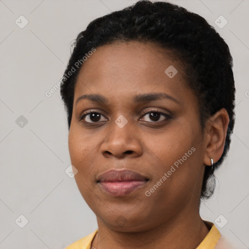 Joyful black young-adult female with short  black hair and brown eyes