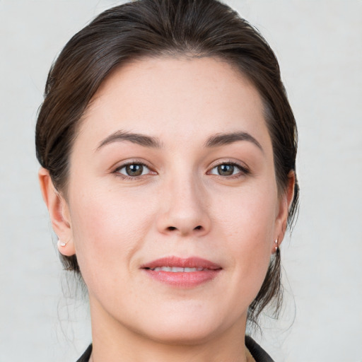 Joyful white young-adult female with medium  brown hair and grey eyes