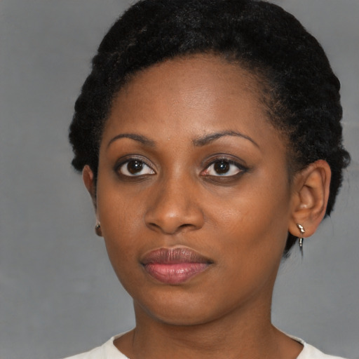 Joyful black young-adult female with short  black hair and brown eyes
