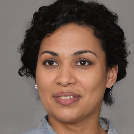 Joyful latino adult female with medium  black hair and brown eyes