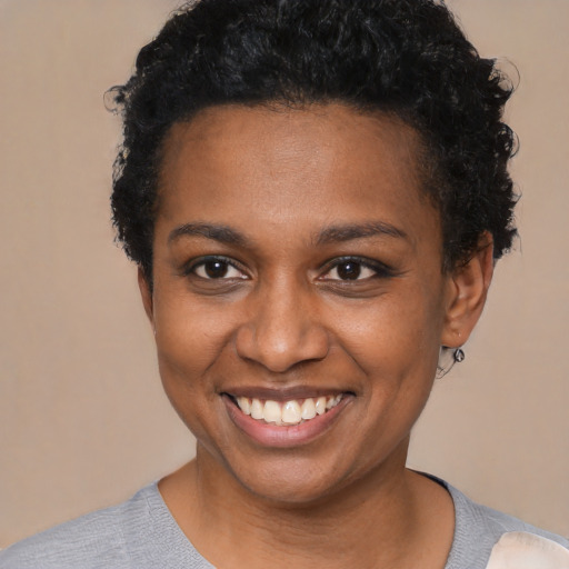 Joyful black young-adult female with short  black hair and brown eyes