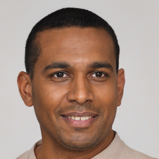 Joyful black young-adult male with short  black hair and brown eyes