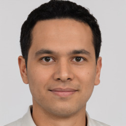 Joyful latino young-adult male with short  brown hair and brown eyes