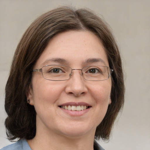 Joyful white adult female with medium  brown hair and green eyes