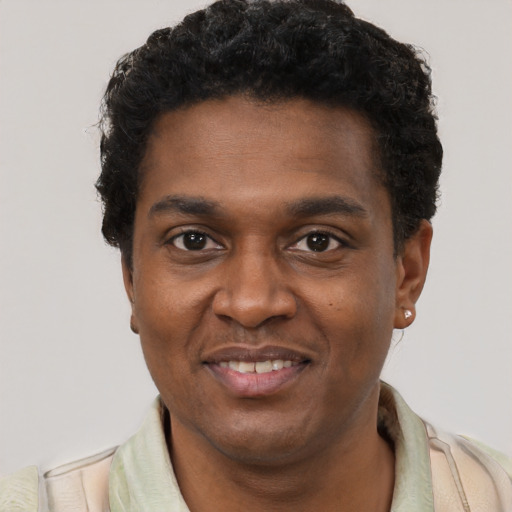 Joyful black young-adult male with short  black hair and brown eyes