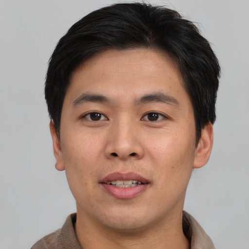Joyful asian young-adult male with short  brown hair and brown eyes