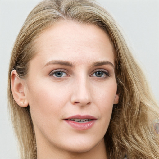 Joyful white young-adult female with long  brown hair and blue eyes