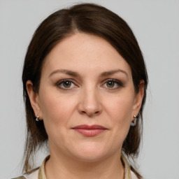 Joyful white adult female with medium  brown hair and grey eyes