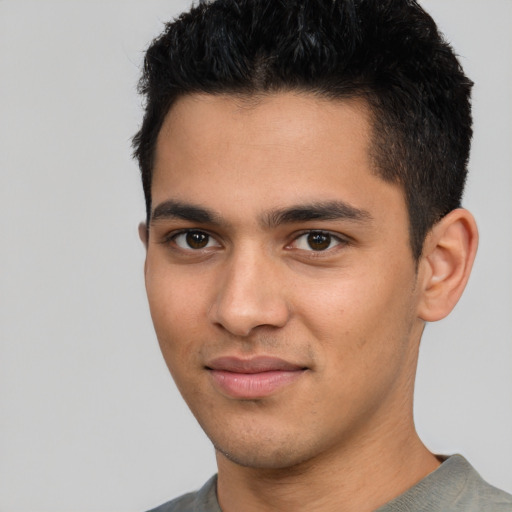 Joyful latino young-adult male with short  black hair and brown eyes