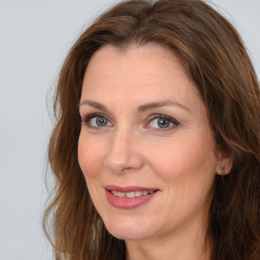 Joyful white adult female with long  brown hair and brown eyes