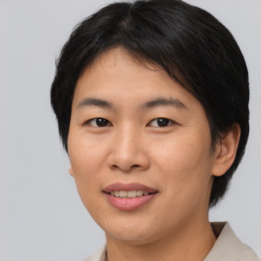 Joyful asian young-adult female with short  brown hair and brown eyes