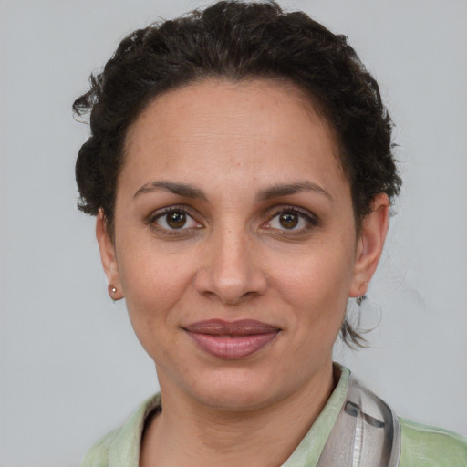 Joyful latino adult female with short  brown hair and brown eyes