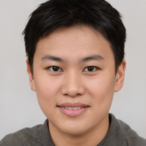 Joyful asian young-adult male with short  brown hair and brown eyes